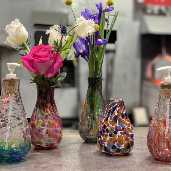 Soap Dispensers and tall vases with flowers on marver - wide